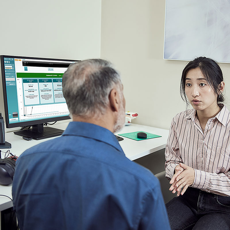 Clinician counseling their client on the results of the ACT test, also known as the ACT value, which is displayed on a screen next to them