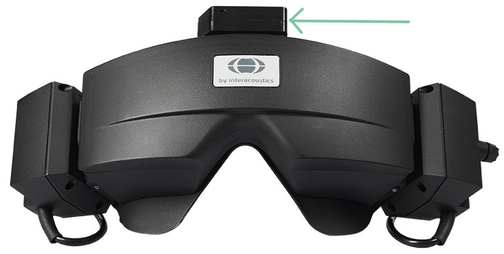 VNG goggles seen from the front with the cover on. A green arrow is pointing toward a small head sensor, which is fixated to the top of the goggles, and would be located around the high forehead if a patient were wearing them.