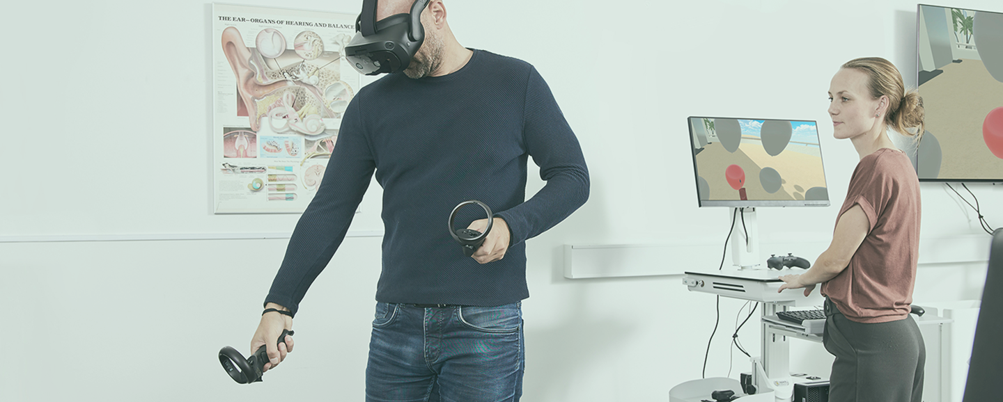 Person in blue shirt wearing VIVE VR goggles