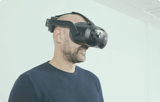 Person in blue shirt wearing VIVE VR goggles