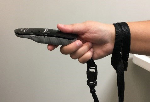 Person holding SVV remote control. Lanyard attached to patient's wrist, which is connected to the remote.
