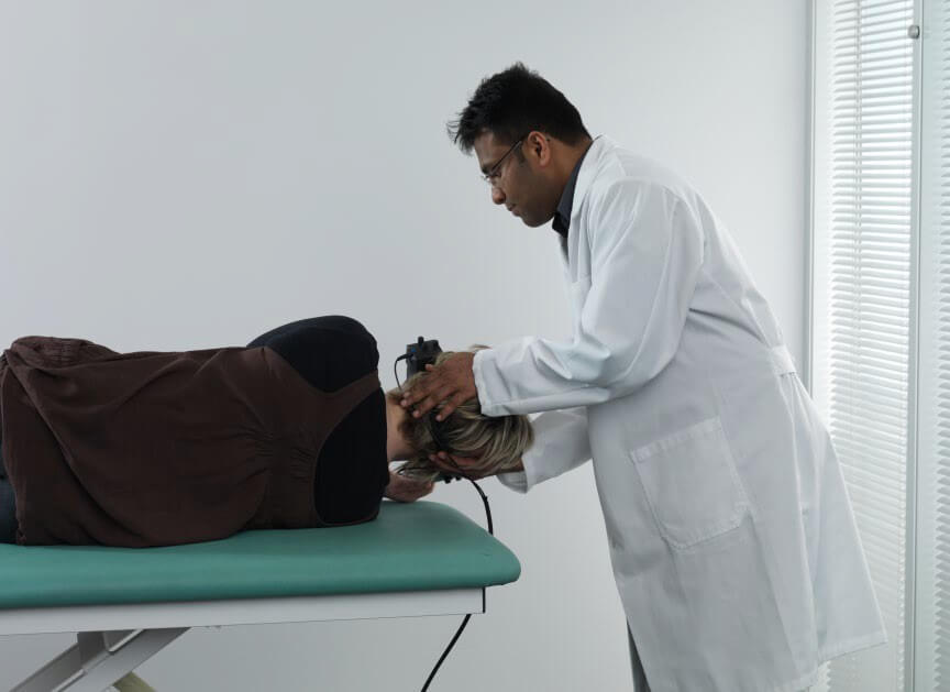 Male clinician rolling female patient onto her right.