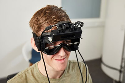 Man wearing VNG goggle, with red arrow pointing toward the location of the VORTEQ IMU.