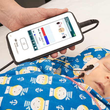 Person holding the Sera while performing hearing screening in sleeping baby