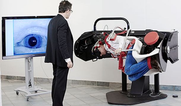 Male clinician performing positioning maneuver on male patient in TRV Chair