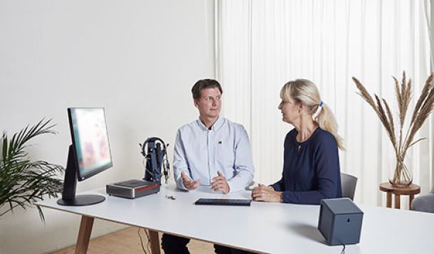 Male clinician counseling female client on hearing aid choices using visible speech mapping
