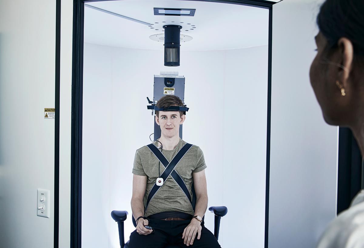 Young man in Orion Auto-Traverse chair holding a remote