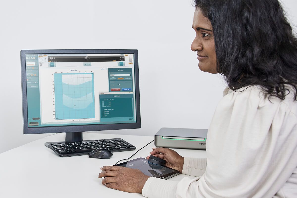 An audiologist is looking at her screen that displays the Automated ticksheet available with the Equinox Evo pediatric module 