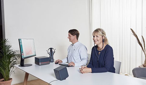 Male clinician performing real ear measurement in female client