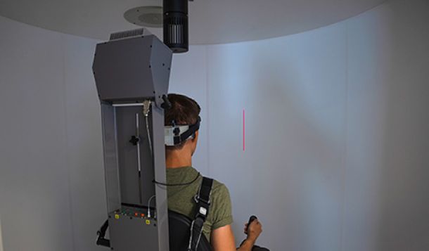 Male patient performing subjective visual vertical test in rotary chair