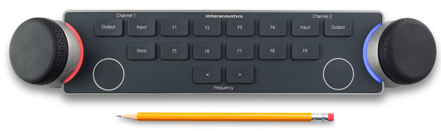 Audiometer Keyboard seen from above with a pencil below. For size comparison, the pencil is approximately two thirds the width of the keyboard. There are two dials located on the left and right sides of the keyboard. The dials are encircled by LED lights which indicate different functions when in use. There are several keys between the multi-functional dials, which include and are not limited to input and output for channels one and two, store, two keys to decrease or increase the intensity, and nine F-keys labeled F1 to F9.