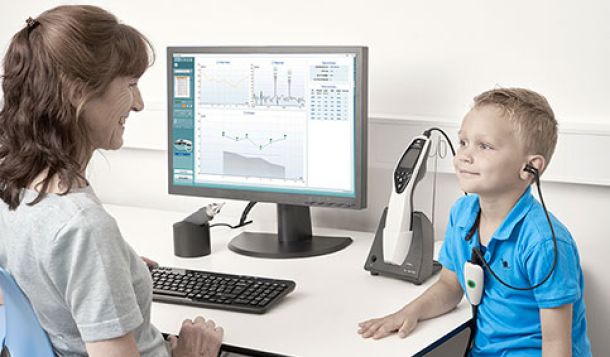 Female clinician performing pressurized DPOAE in young boy