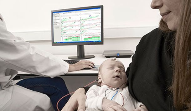 ASSR hearing test in baby lying down in mother's arms